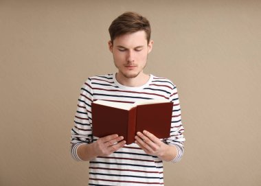 Genç adam renk arkaplanı kitabı okuyor