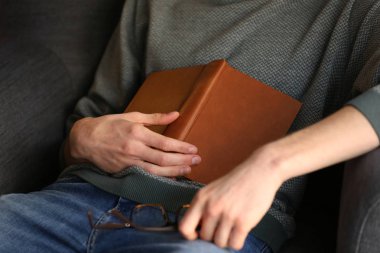 Evde, koltukta, closeup uyku kitap ile genç adam