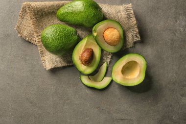 Koyu gri arka plan üzerinde olgunlaşmış avokado ile kompozisyon