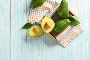 Hafif ahşap arka plan üzerinde olgunlaşmış avokado ile kompozisyon