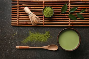 Koyu gri arka plan üzerinde toz matcha çay ile kompozisyon