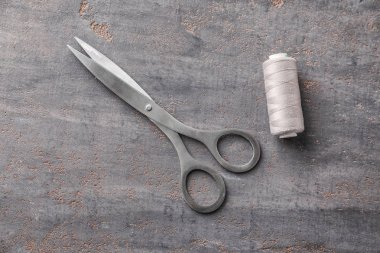 Dikiş ipliği ve gri arka plan için makaslar