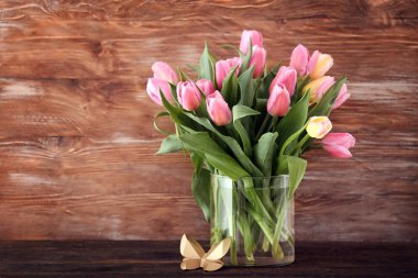 Ahşap arka plan karşı masada güzel lale vazo