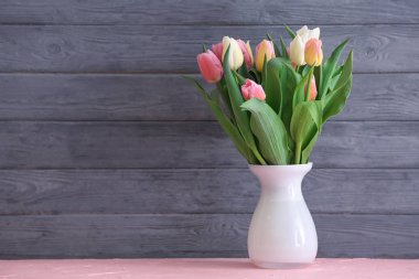 Ahşap arka plan karşı masada güzel lale vazo