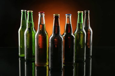 Taze bira koyu arka plan üzerinde cam şişelerde