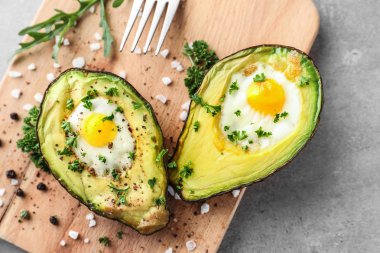 Ahşap tahta üzerinde yumurta ile pişmiş avokado