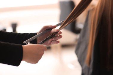 Profesyonel kuaför müşteriyle kuaförde çalışıyor.