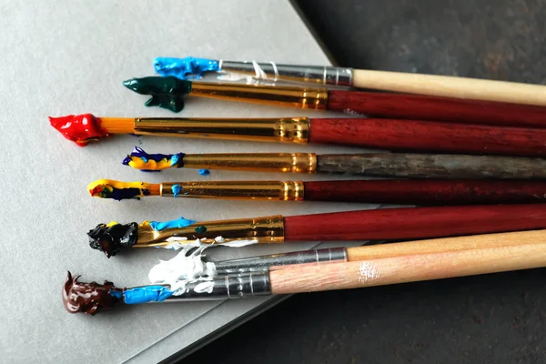 Boya fırçaları masada, closeup ile defter