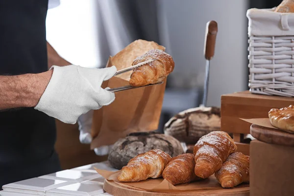 Young Man Putting Croissant Paper Bag Tongs Bakery — Stock Photo, Image