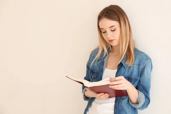Ung Kvinna Läsa Bok Nära Ljus Vägg — Stockfoto