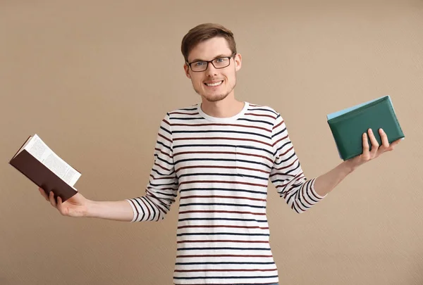 Junger Mann Mit Büchern Auf Farbigem Hintergrund — Stockfoto