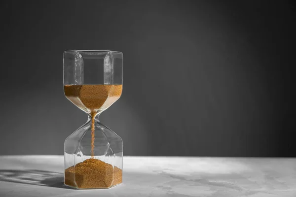 暗い背景にテーブル上に砂時計 時間管理の概念 — ストック写真