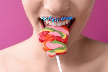 Yaratıcı makyaj ve lolipop renk arka plan, closeup üzerinde olan güzel kadın