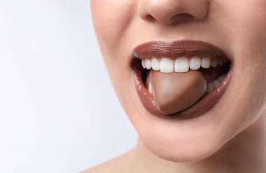 Güzel genç kadın ile ağız beyaz arka planda, closeup çikolata şeker