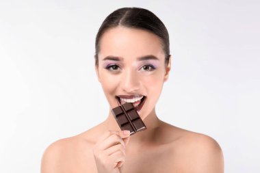 Beyaz arka planda çikolata olan güzel genç bir kadın.