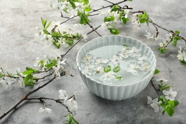 Su ve masaya çiçek açan çiçek ile kase