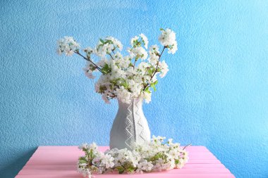 Tablo renkli duvarının yakınında güzel çiçek açması dallarında vazo