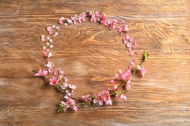 Güzel çiçek dalları ve yaprakları ahşap arka plan üzerinde çerçeve yaptı