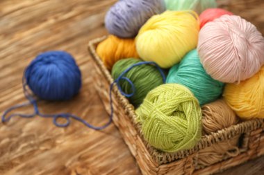 Ahşap masa üzerinde renkli örgü iplikleri ile hasır sepet