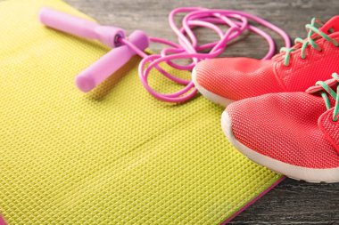 Yoga mat ile ip atlama ve ahşap zemin, closeup üzerine spor ayakkabı