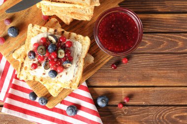 Tereyağı, reçel ve ahşap masa üzerinde taze meyveleri lezzetli tatlı tost