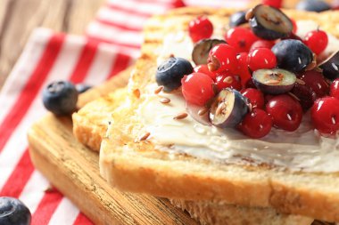 Tereyağı ve ahşap masa, closeup üzerinde taze çilek ile lezzetli tatlı tost