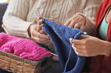 Kanepeye, closeup oturan iplik örgü ile Olgun kadın ve Genç