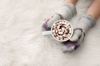 Evde küçük kızın elleriyle sıcak kakao fincan içmek