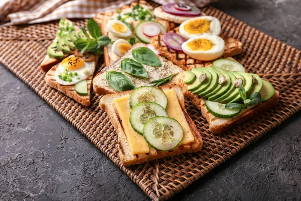 Different Delicious Toasts Wicker Mat — Stock Photo, Image