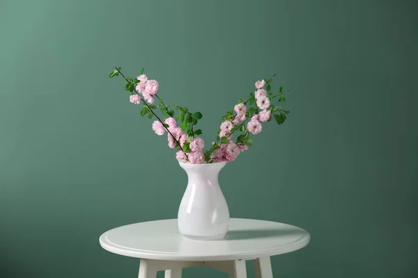 開花枝色背景にテーブルの上の花瓶 — ストック写真
