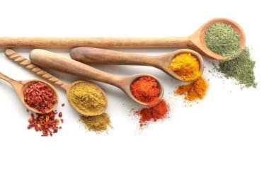 Beyaz arka plan üzerinde çeşitli baharatlar ile tahta kaşıklar