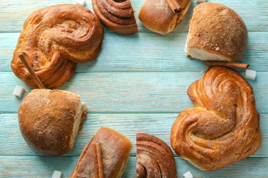 Ahşap arka plan üzerinde tatlı tarçınlı çörek ile kompozisyon