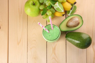 Lezzetli avokado güler yüzlü ve ahşap masa üzerinde taze meyve ile cam kavanoz