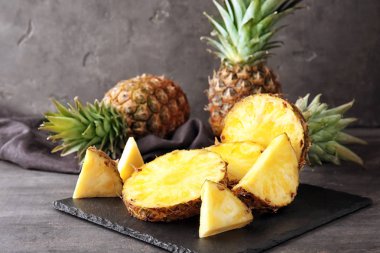 Kayrak plaka ile lezzetli ananas masanın üstüne kesmek.