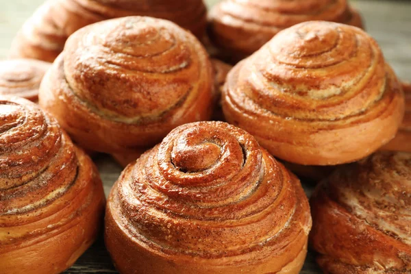 Sweet cinnamon buns on table, closeup