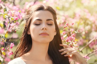 Güzel genç kadının yanına park bahar gününde çiçek açan ağaç