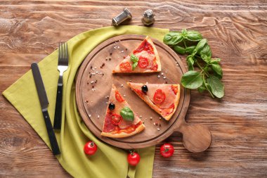 Tahta parçaları, düz ahşap arka plan üzerinde lezzetli pizza ile yatıyordu