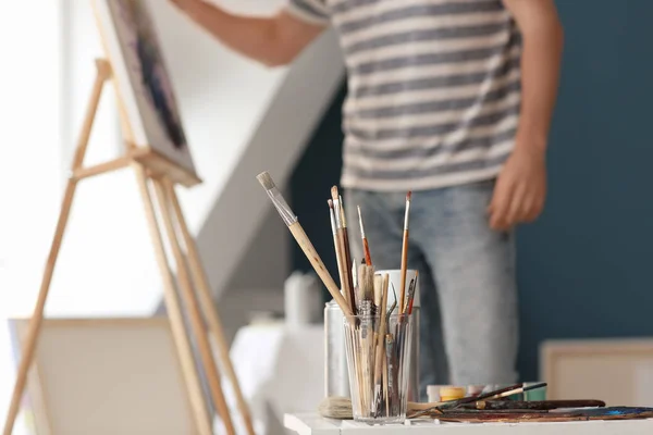 Table with paint tools in artist's workshop