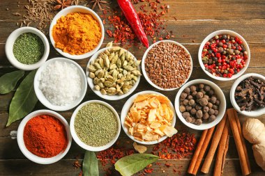 Ahşap arka plan üzerinde çeşitli baharatlar ile kase