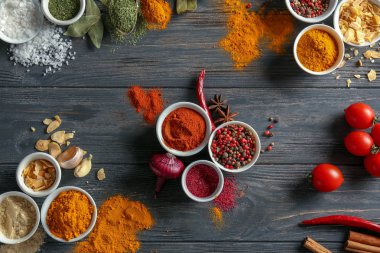 Ahşap arka plan üzerinde çeşitli baharatlar ile kase