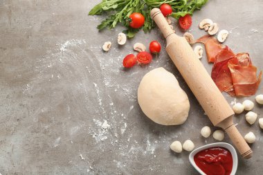 Pizza masada malzemelerle çiğ hamur