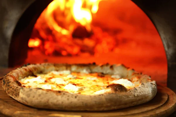 ボード上の台所で薪オーブンの近くのおいしいピザ — ストック写真