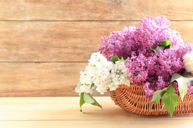 Güzel çiçek açması leylak masada ahşap arka plan ile sepet