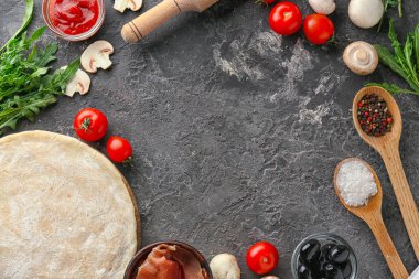 Çiğ hamur ve gri arka plan üzerinde pizza için malzemeler ile kompozisyon