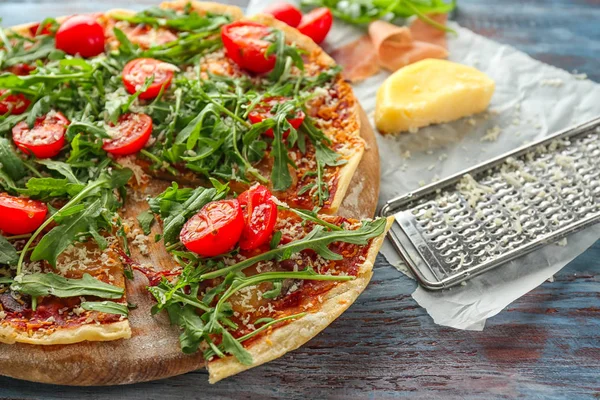 Wooden board with tasty pizza on table