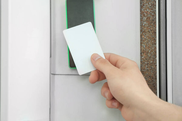 Man opening door with security card outdoors