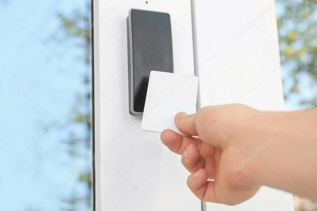 Man opening door with security card outdoors