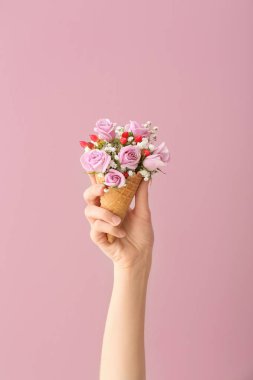 Gözleme koni güzel çiçekler ile renk arka plan üzerinde tutan kadın