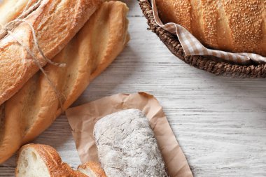Beyaz ahşap masa üzerinde farklı taze lezzetli ekmek