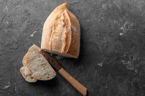 テーブルの上のナイフとカット新鮮なおいしいパン — ストック写真